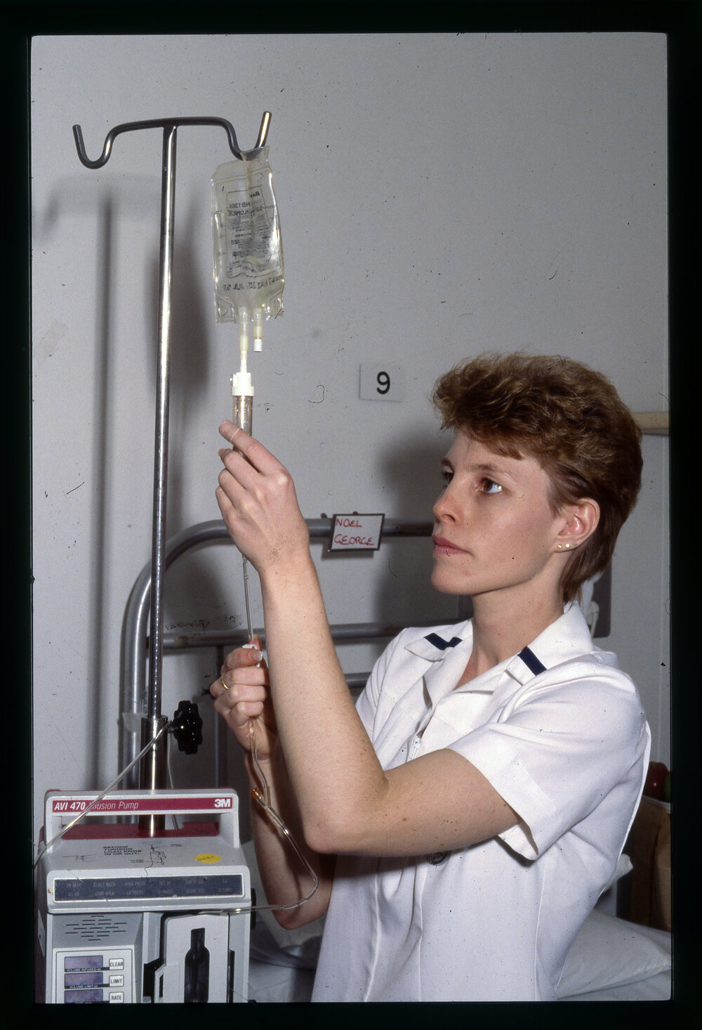 Nursing Student Adjusting Saline Drip 
