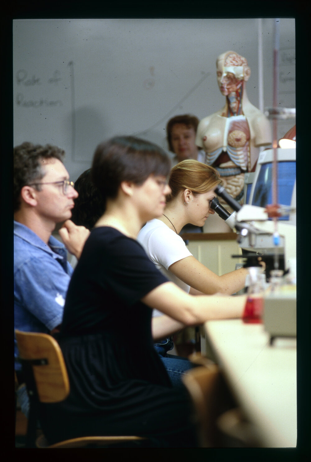Medicine Students in Laboratory Using Microscopes