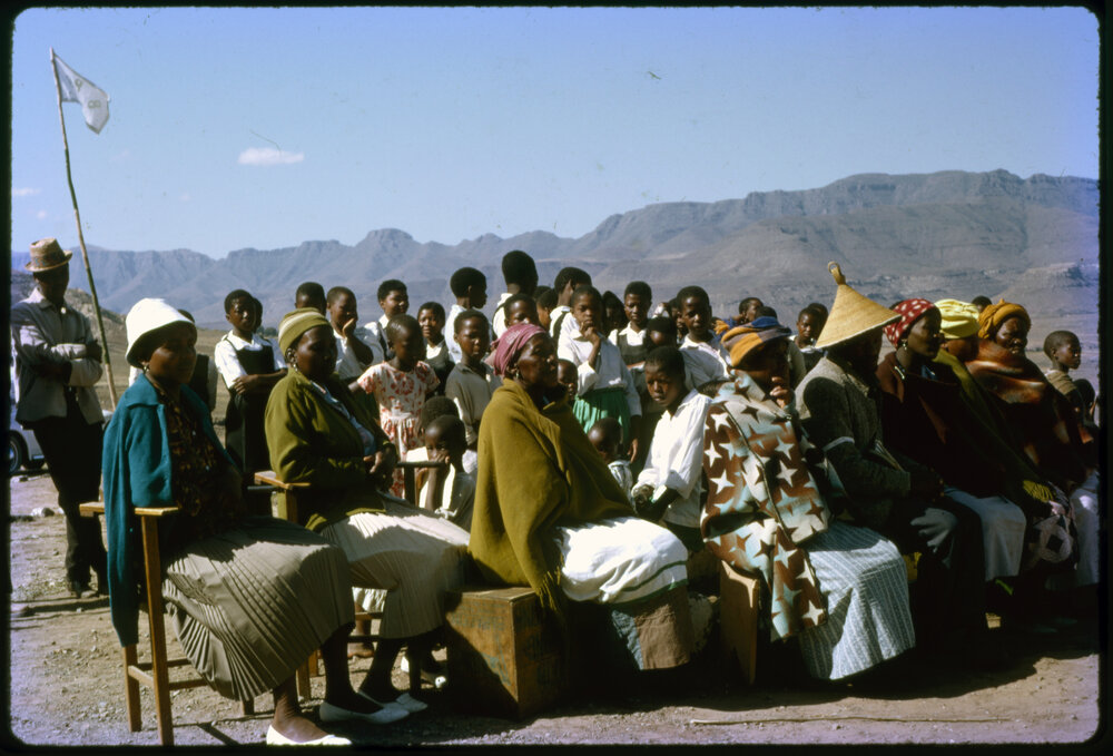 Seated Group with Schoolchildren Behind