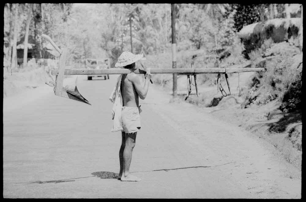 Man Carrying Wooden Equipment