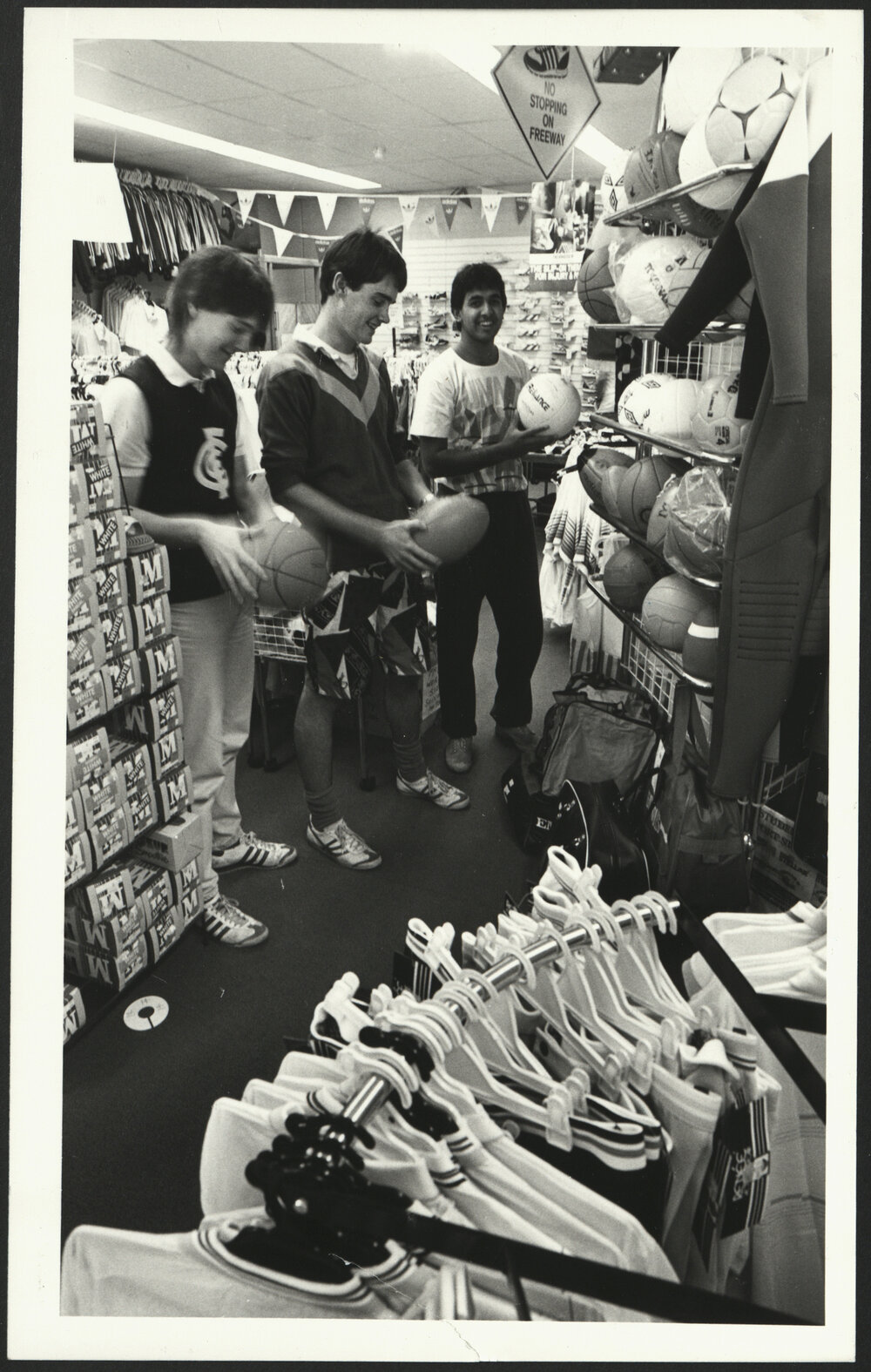 Three Students Checking Out Balls in the  Sports Store of the Sports Union