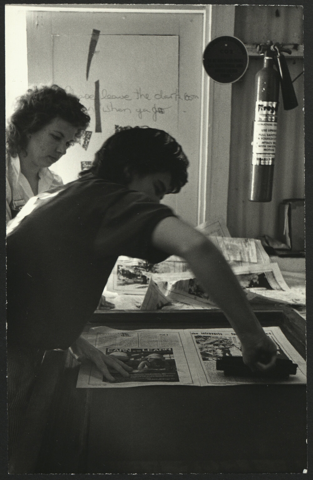 Two Participants in Action Using Newspapers at a Printing Workshop