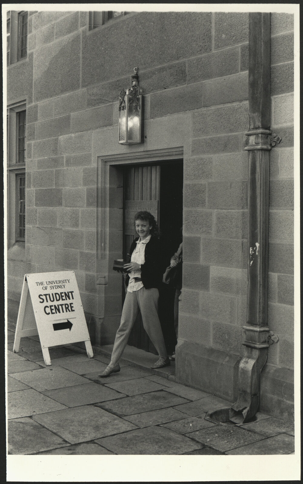 A Female Student Leaving the Student Centre in the Main Quadrangle