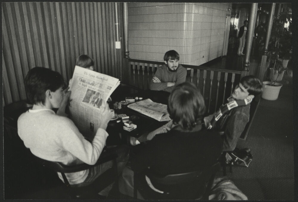 Students at a Round Table Chatting and Reading the Paper in the Wentworth Building