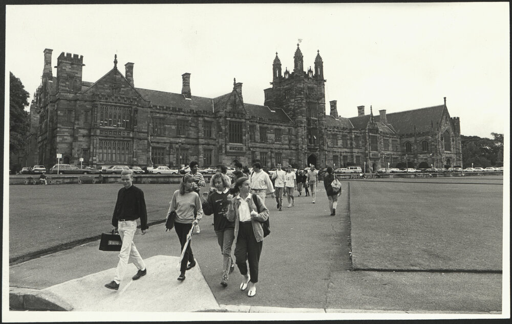 Students Crossing the Front Lawn Towards Fisher Library - Cars Parked in Front of Main Building