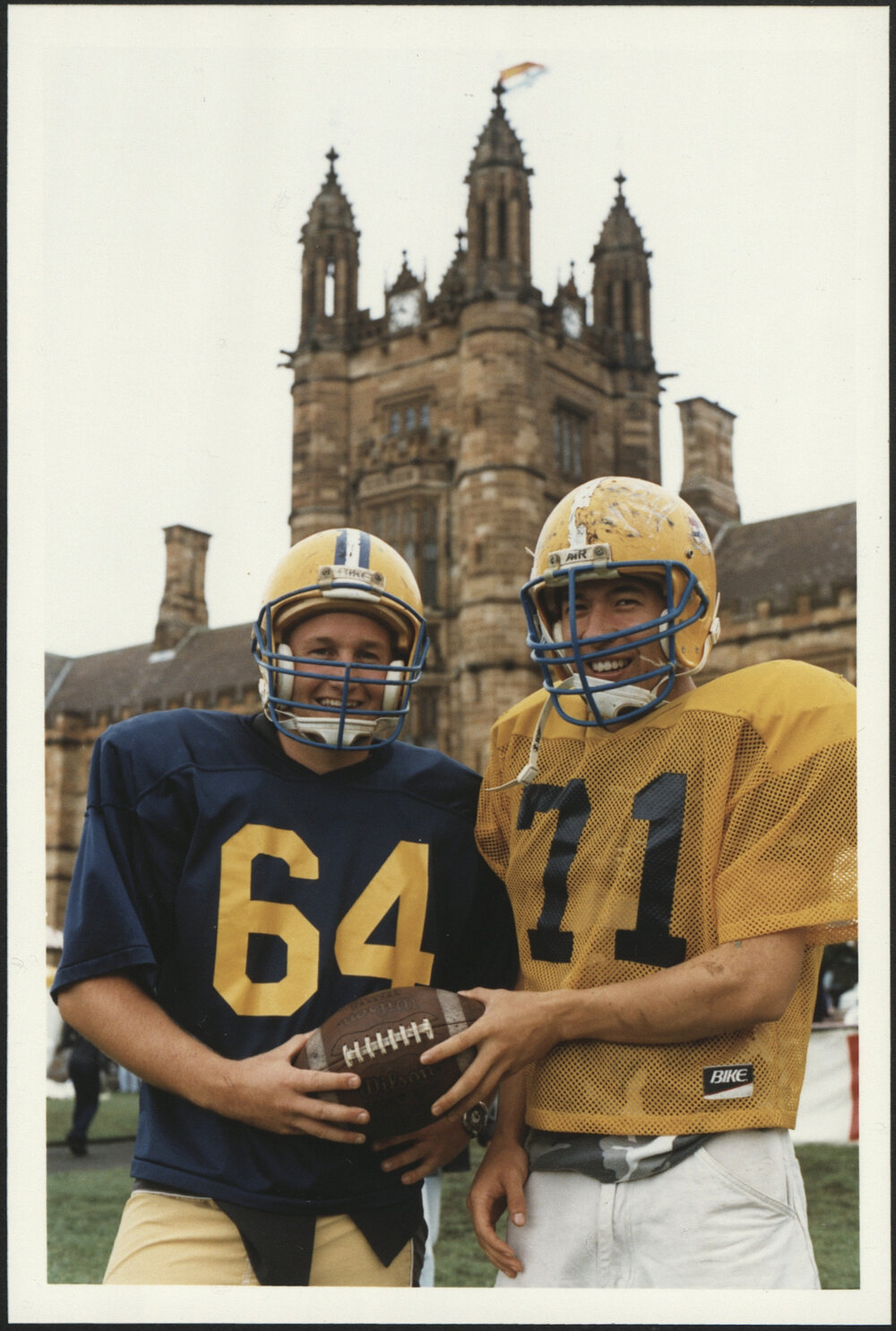 Two Students in Grid Iron Uniforms on the Front Lawn During Orientation/O-Week 1999