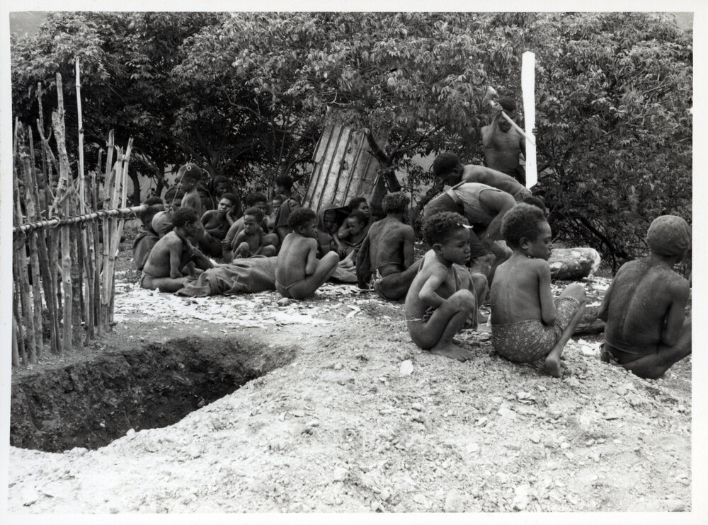Group Sitting Near Grave