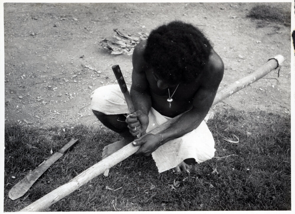 Man Stripping Bark from Log