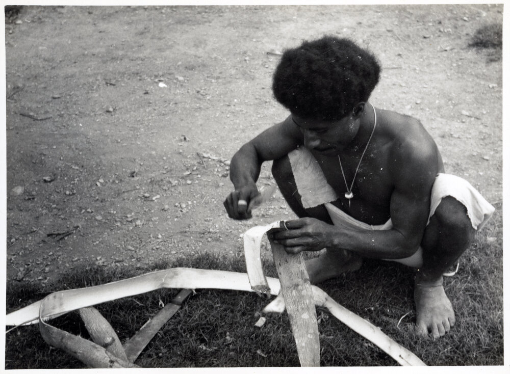 Man Stripping Bark from Log
