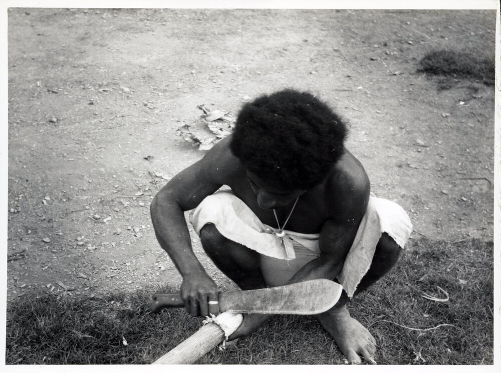 Man Stripping Bark from Log