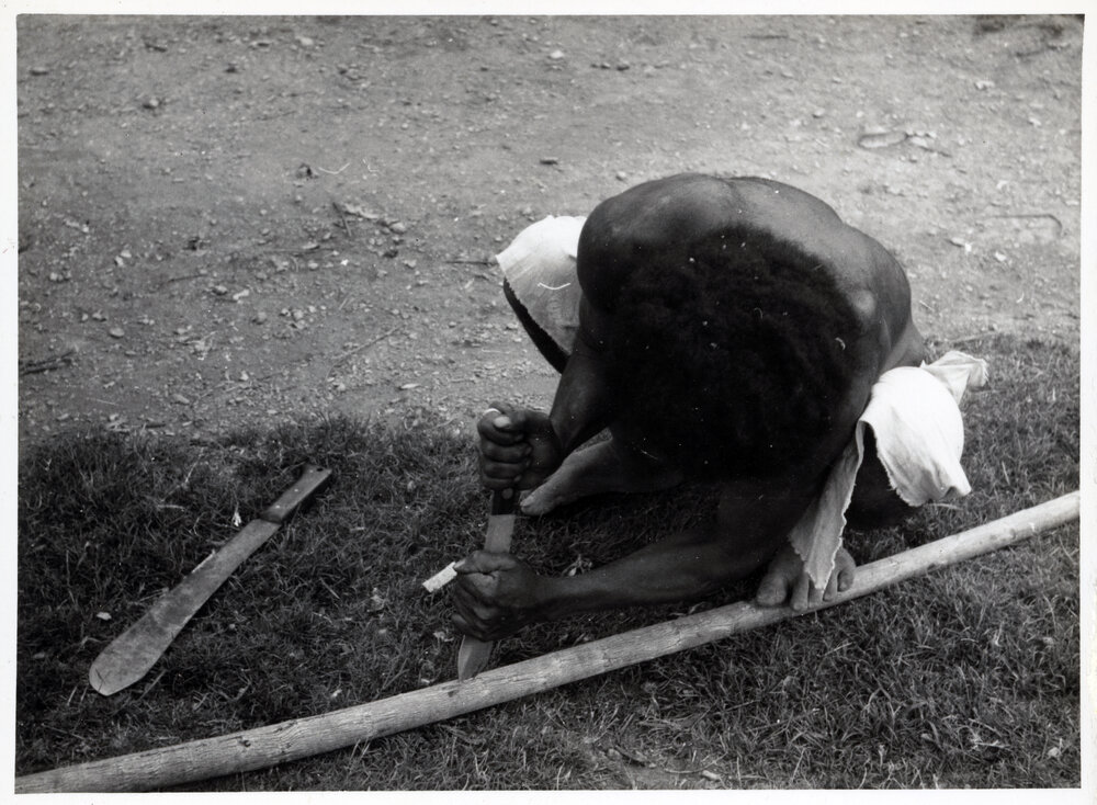 Man Stripping Bark from Log