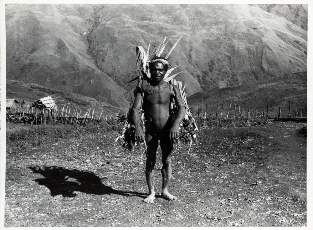 Man Carrying Bags of Logs