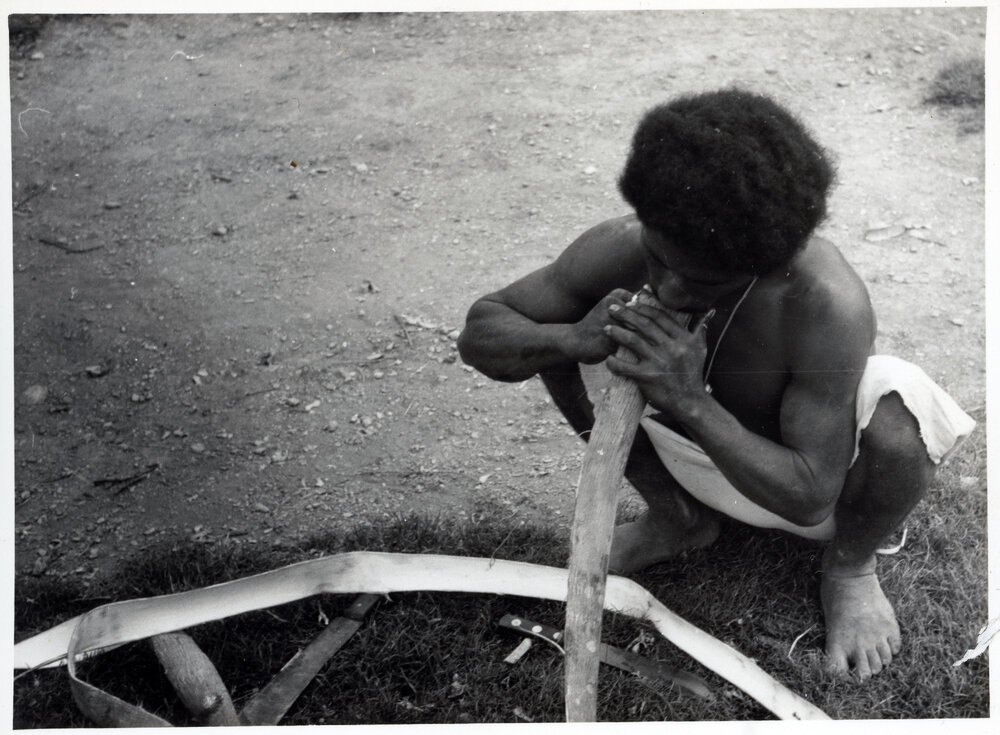 Man Stripping Bark from Log