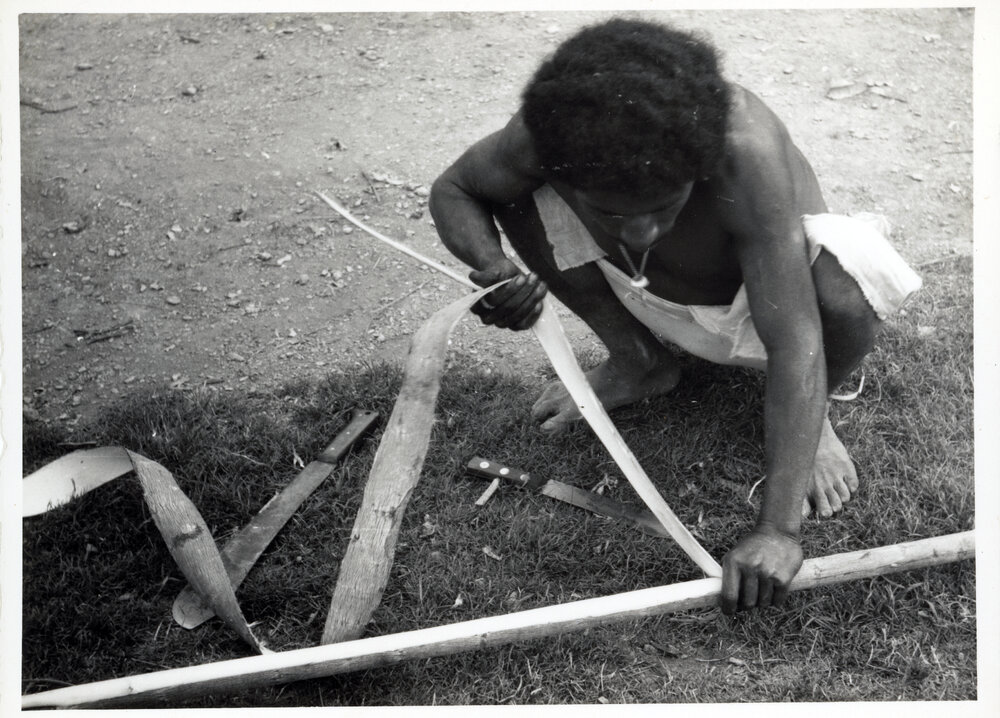 Man Stripping Bark from Log