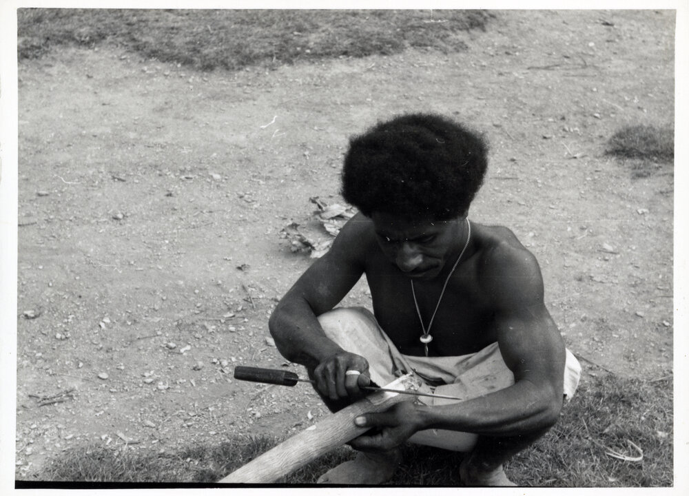 Man Stripping Bark from Log