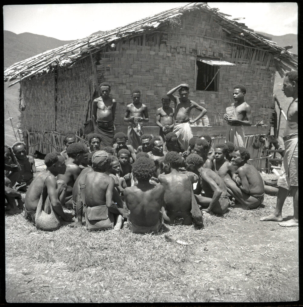 Group Seated Before Standing Men