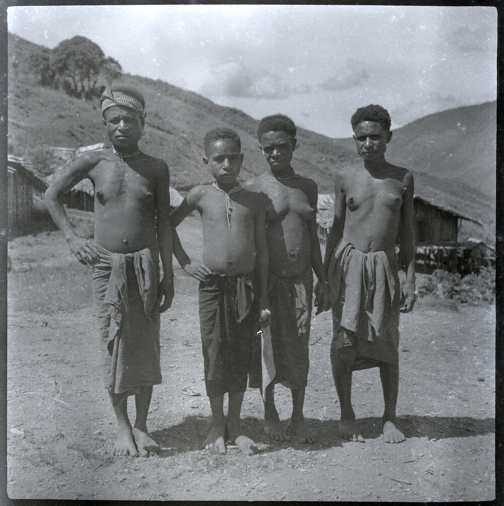 Group of Four Standing in Front of Hamlet