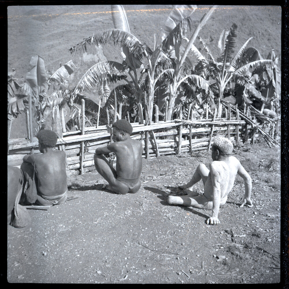 Men Seated, Facing Fence