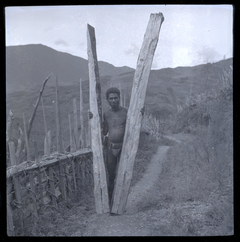 Man Holding Two Large Pieces of Wood