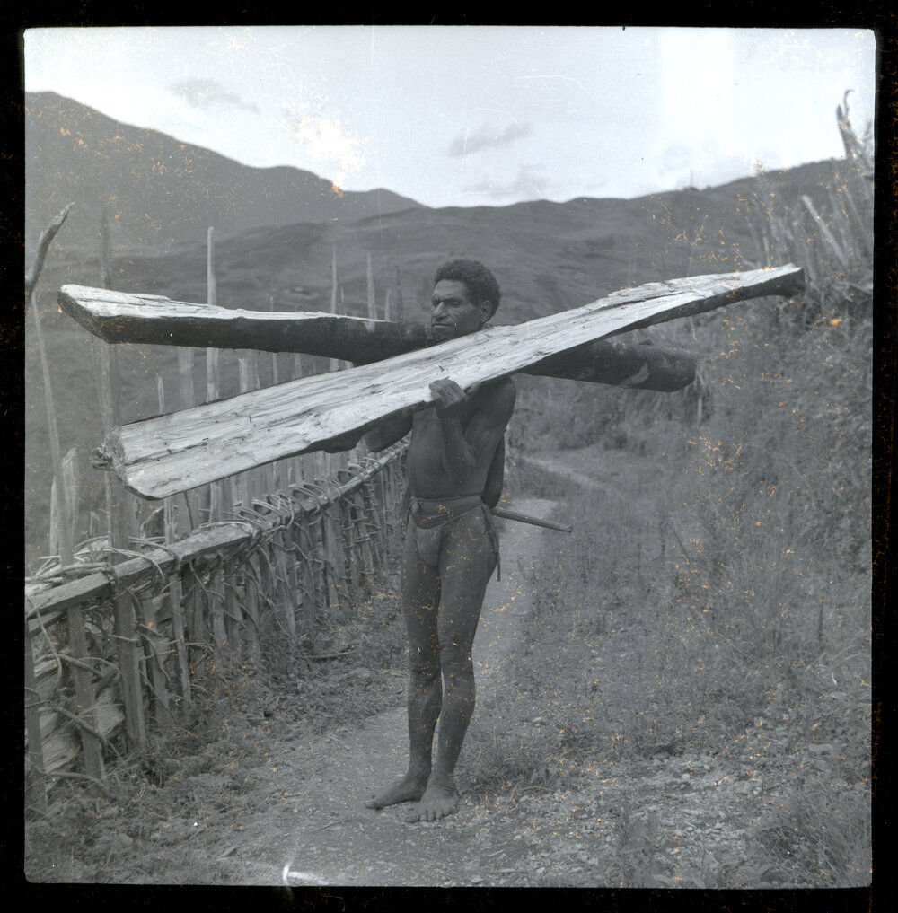 Man Holding Two Large Pieces of Wood