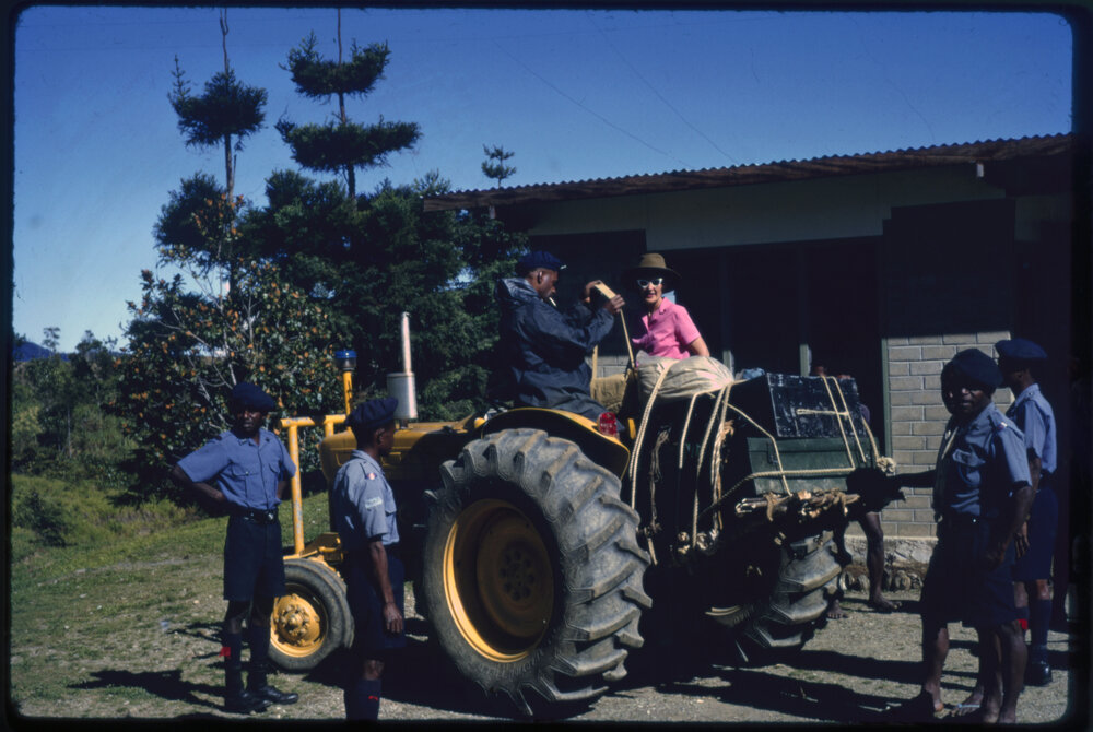 Margaret McArthur on Tractor with Uniformed Men