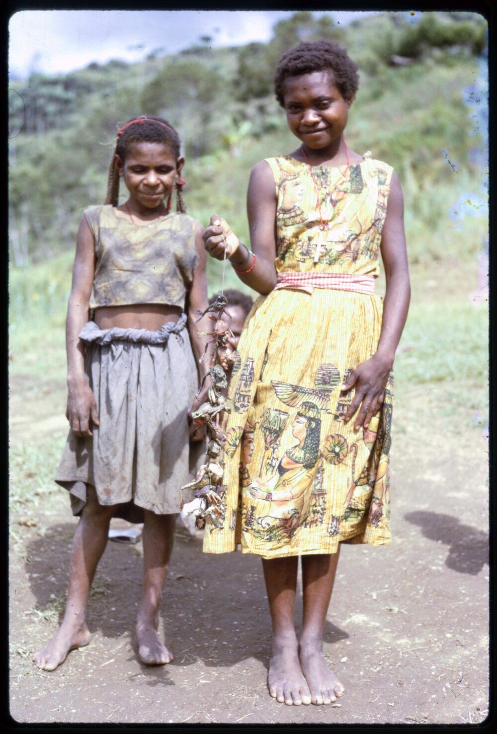 Two Girls, One with a String of Frogs
