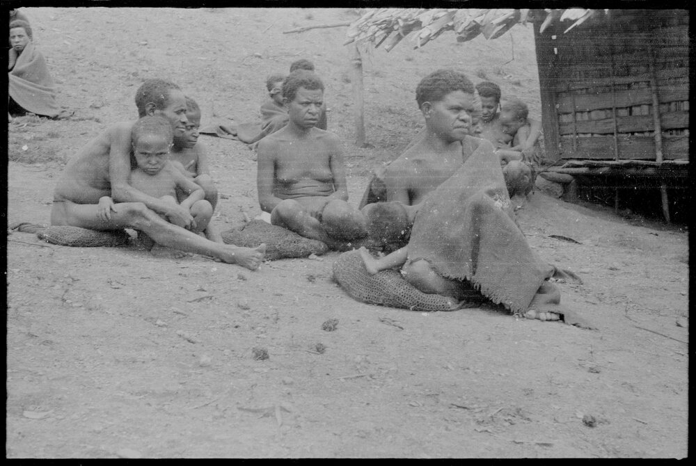 Women and Children Sitting Outside a Building