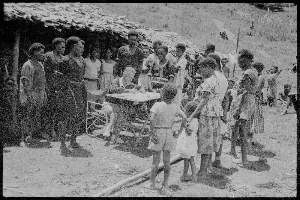 Group Gathered Around Man at Desk