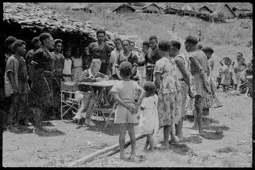 Group Gathered Around Man at Desk