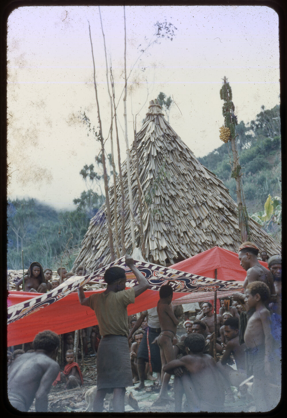 Group Suspending Cloth Through Village