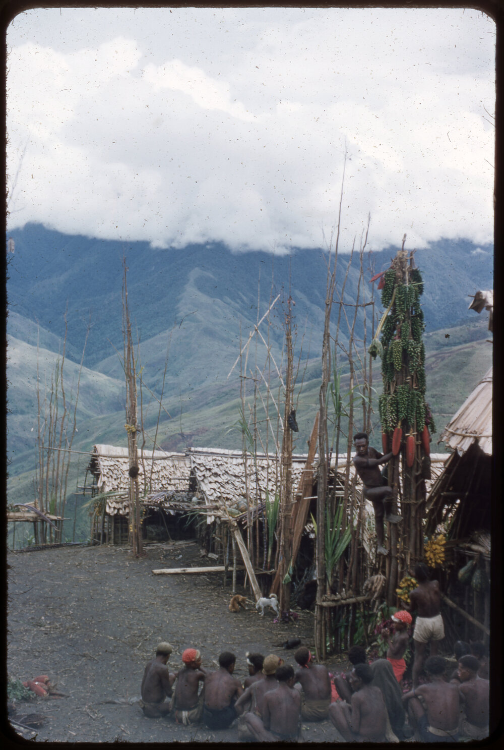 Group of Men Sitting at the Base of a Food Pole