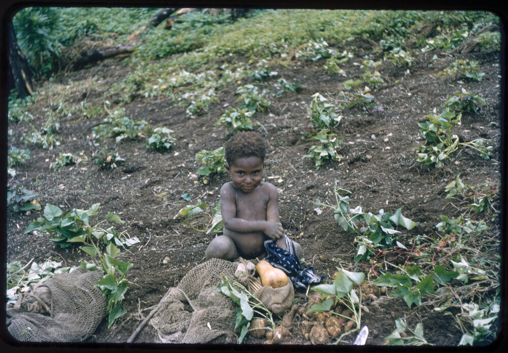 Child Sitting with Vegetables