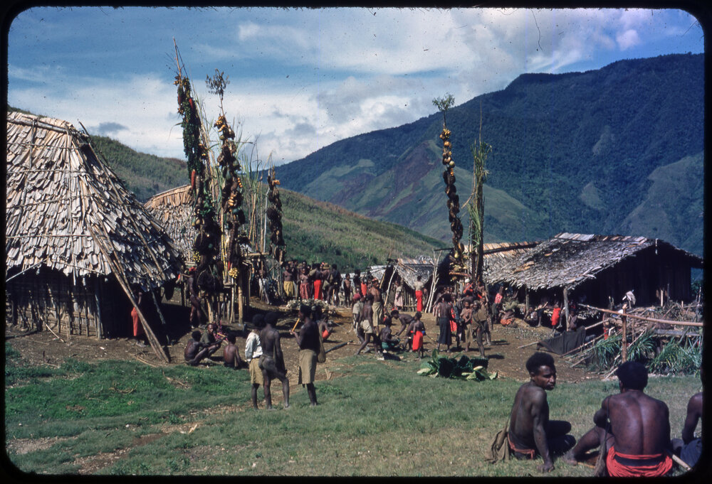 Groups Gathered in Front of Buildings and Food Poles