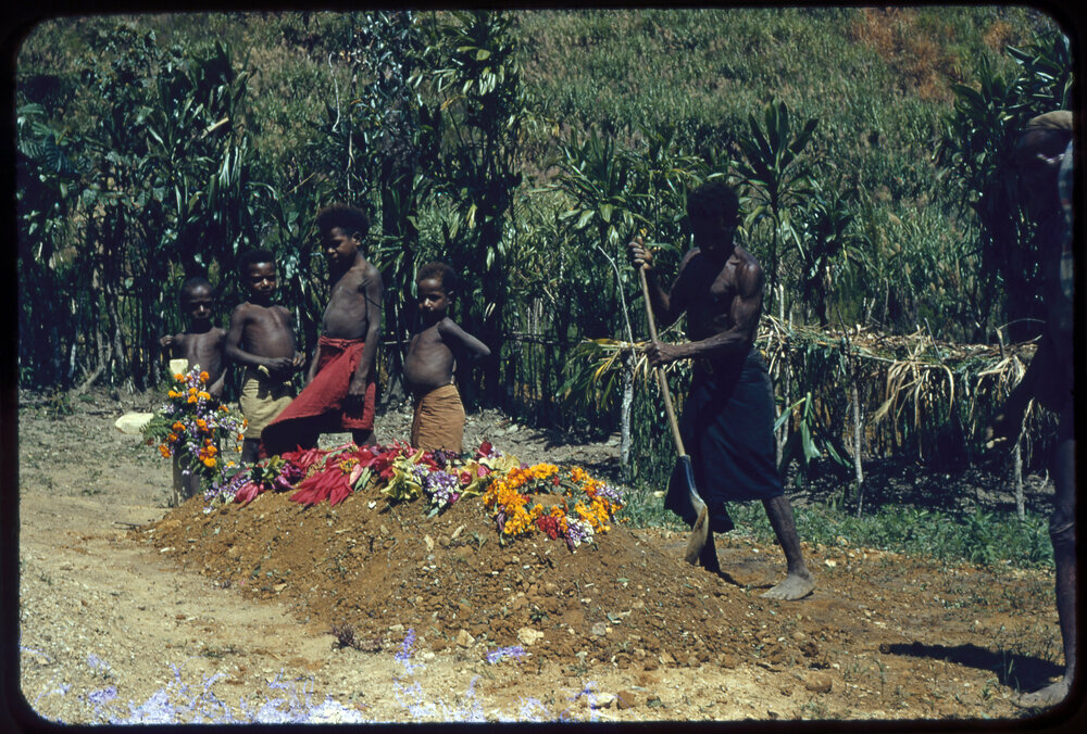 Group Standing Next to Grave