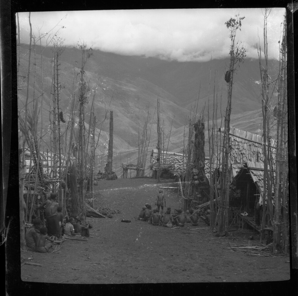 Groups Sitting Outside Buildings with Food Poles