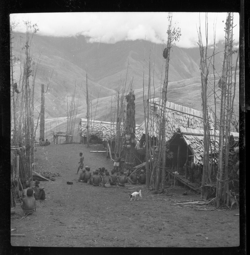 Groups Sitting Outside Buildings with Food Poles