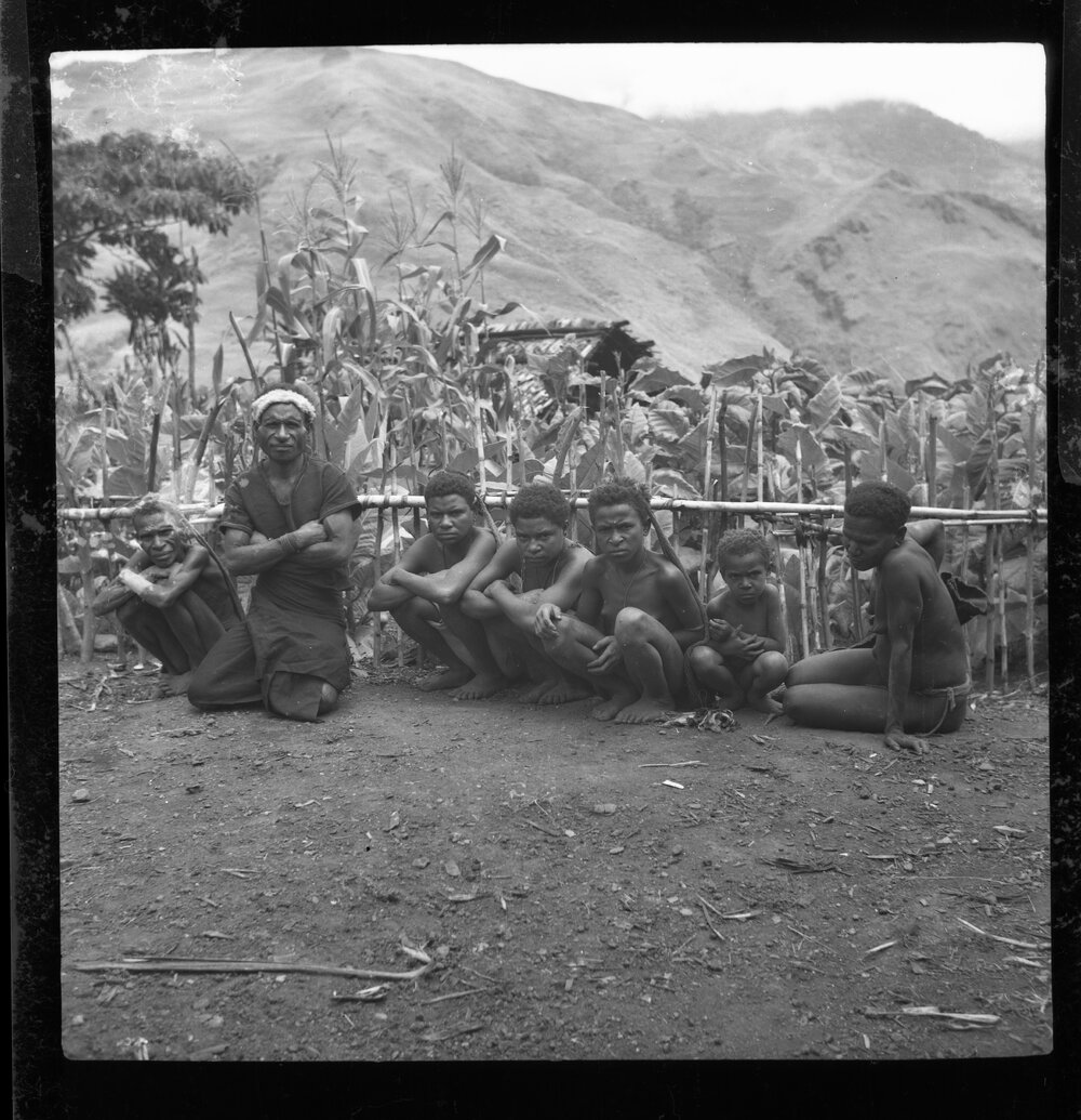 Group Sitting Along a Fence