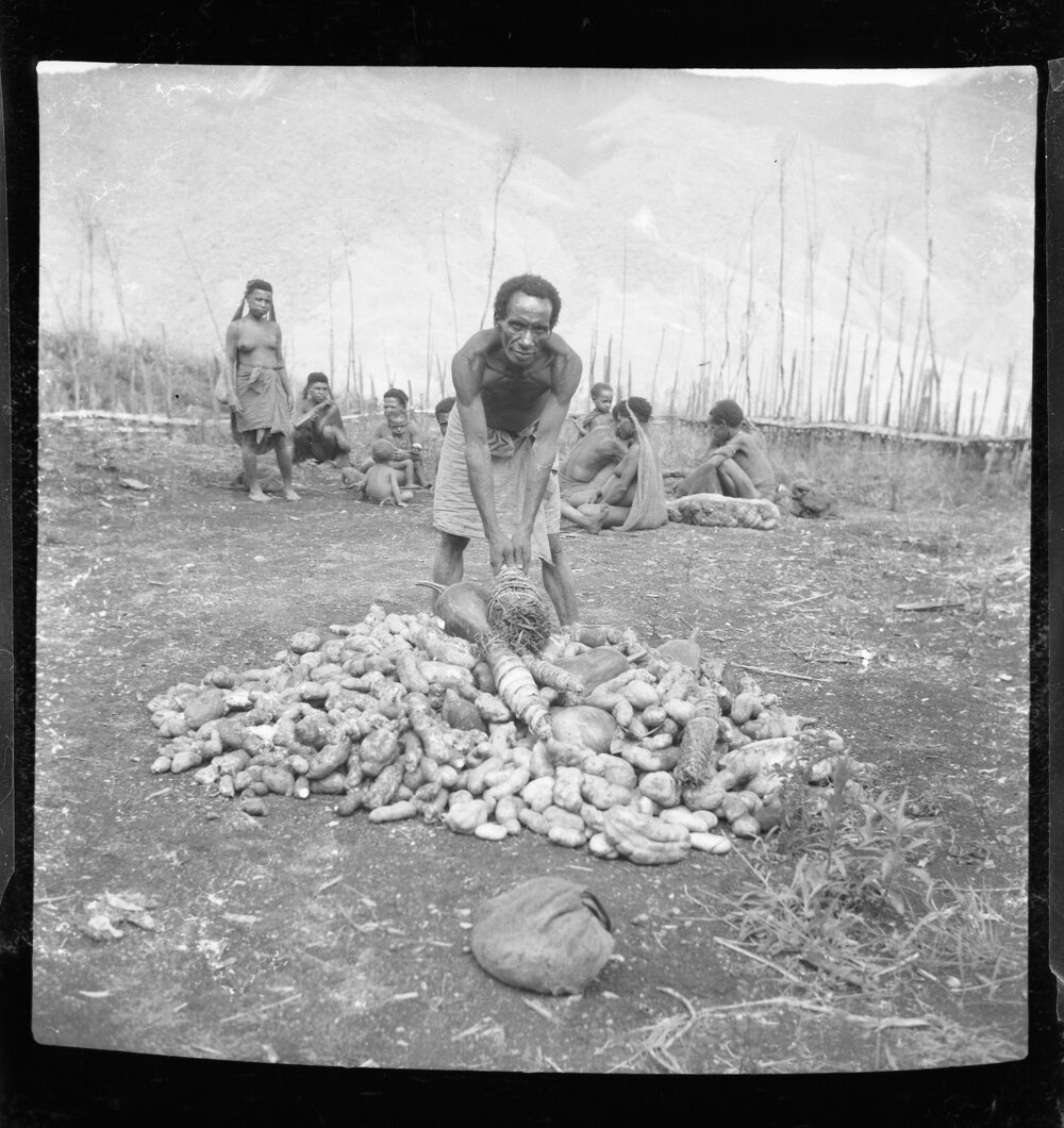 Man Standing with Pile of Vegetables