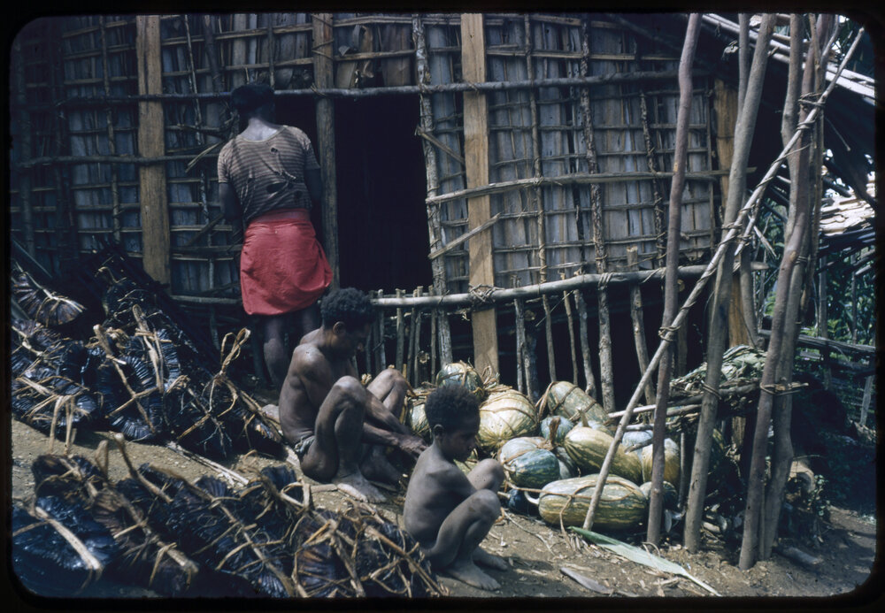 Men and Child Sitting Outside a Building