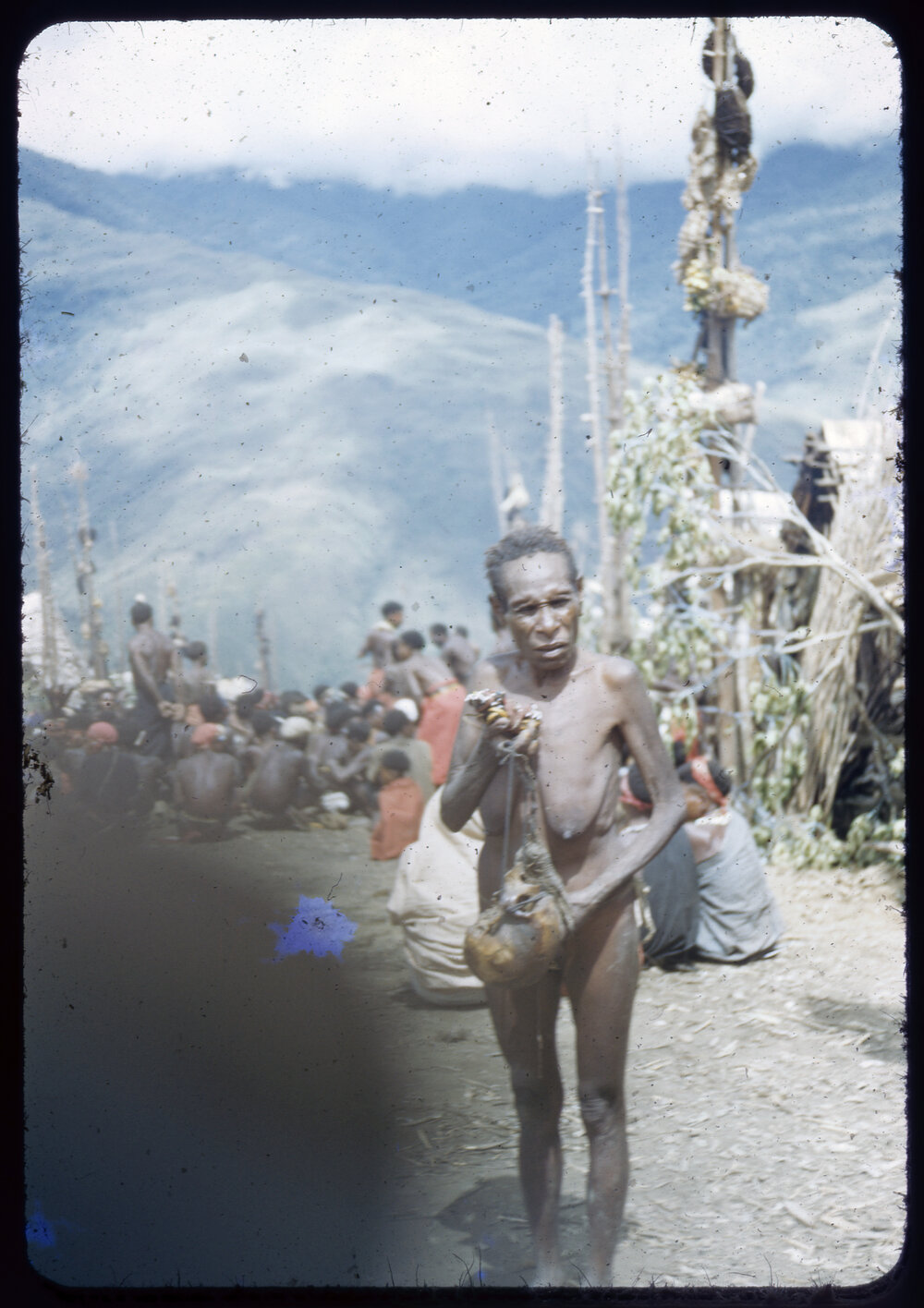 Woman in a Village with Group Gathered Behind