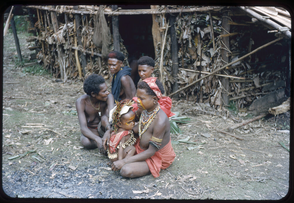 Women and Child Sitting Outside a Building