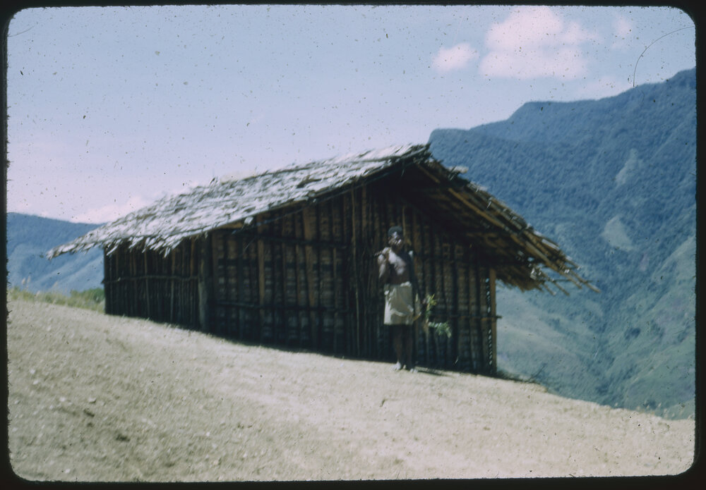 Man Standing Outside Mountainside Building