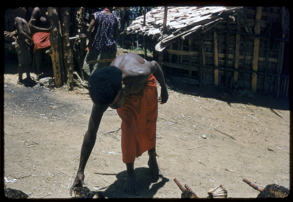 Man Picking up Food from Food Pile