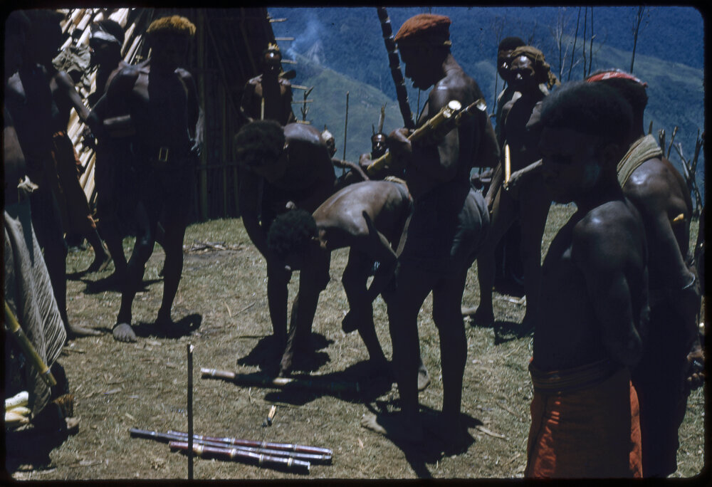 Men Placing Down Sticks to Determine Food Piles