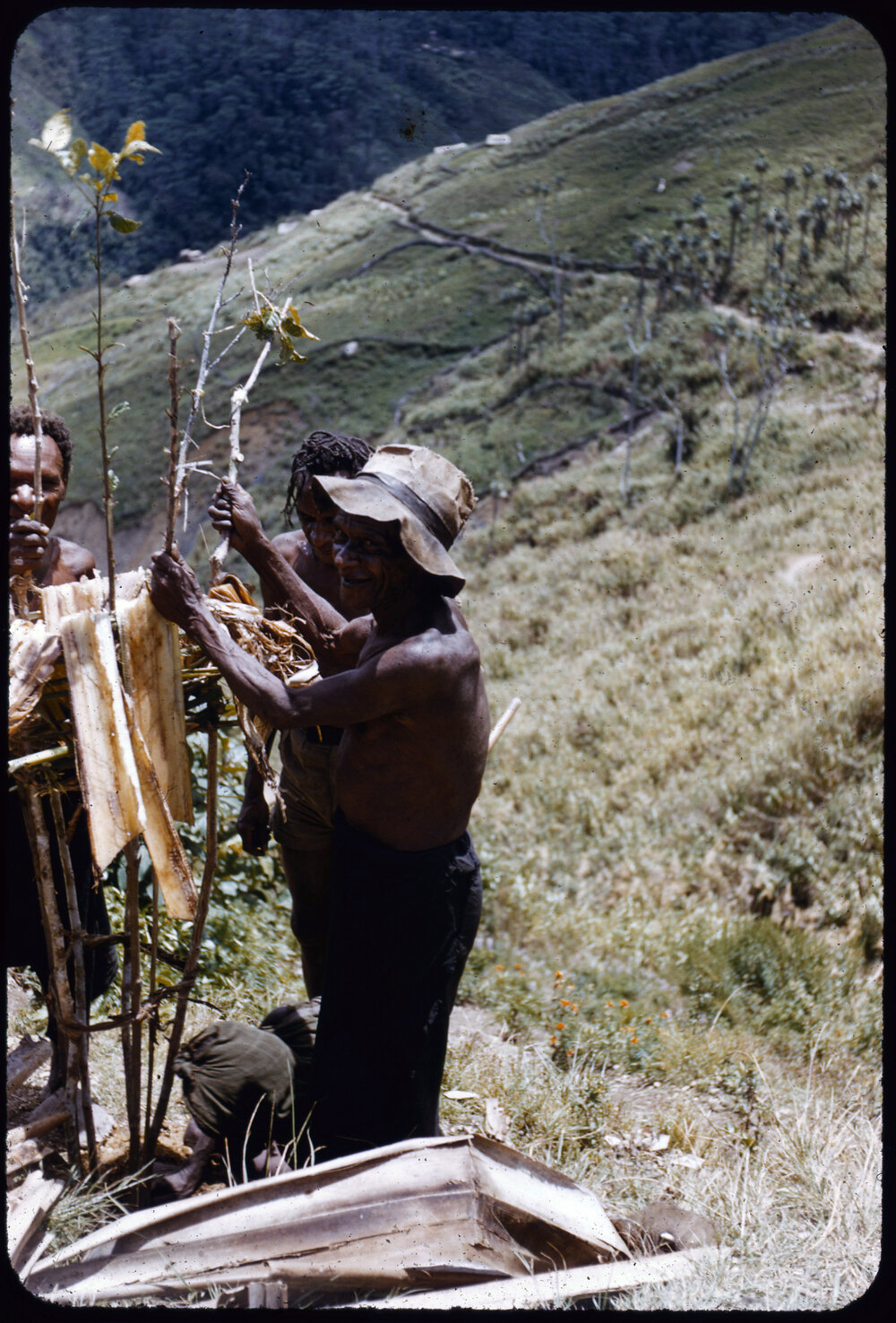 Men Standing Around a Stick Structure
