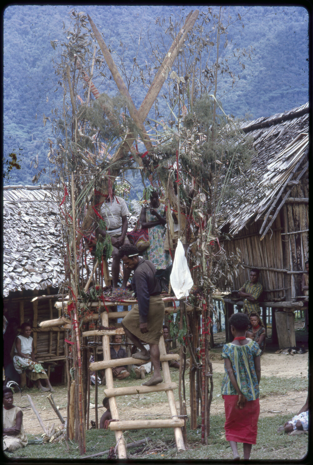 Couple Sitting on Elevated Platform in Village