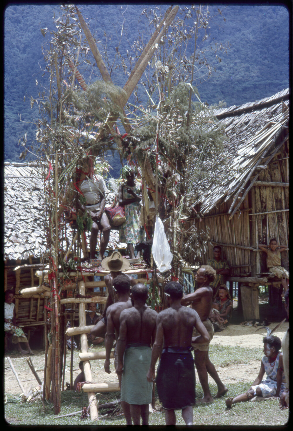 Couple Sitting on Elevated Platform in Village
