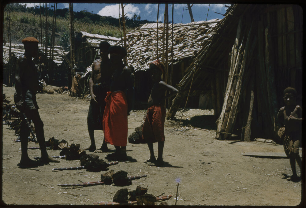 Men and Children Standing Beside Food Piles
