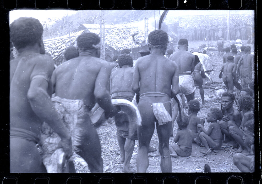 Men Carrying Meat Through a Village