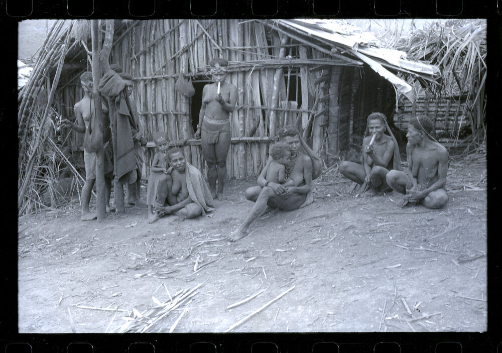 Women and Children Sitting Outside a Building